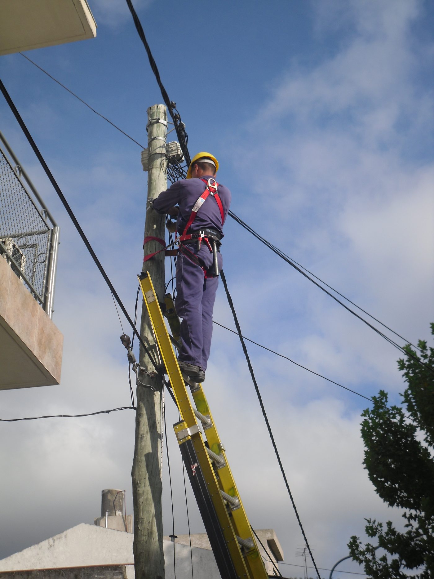 Cuadrilla de planta externa tendiendo fibra óptica sobre poste